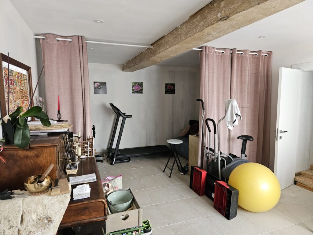 vue avant projet d'une pièce de 15 m² avec zone de stockage et espace détente derrière des rideaux